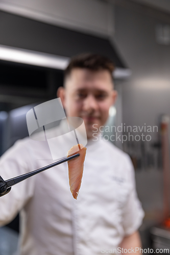 Image of Chef showing a perfect slice of smoked fish