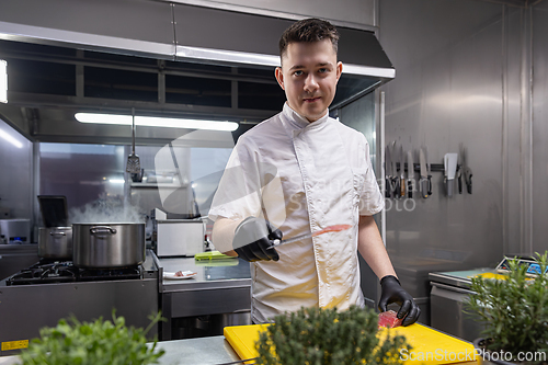 Image of Chef holding slice of smoked fish