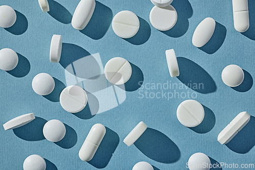 Image of white pills on blue background