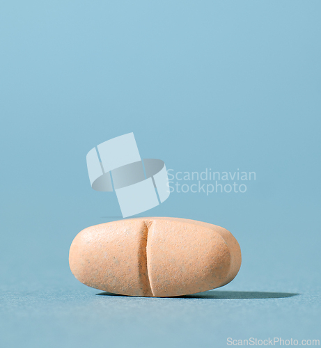 Image of orange pill on blue background