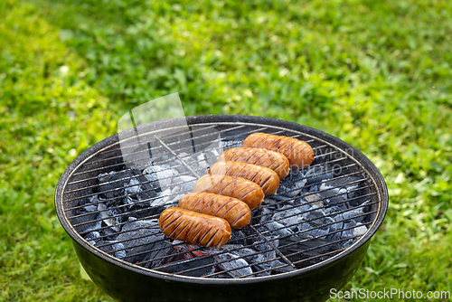 Image of grilled sausages on charcoal grill