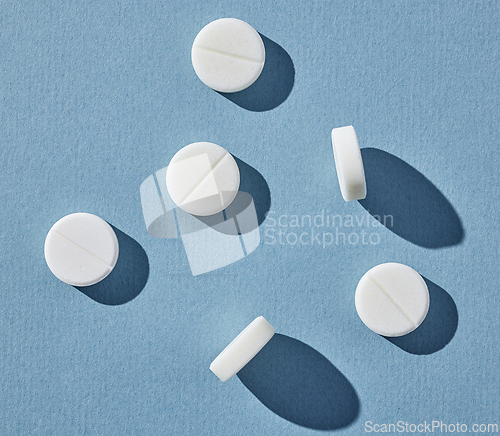 Image of white pills on blue background