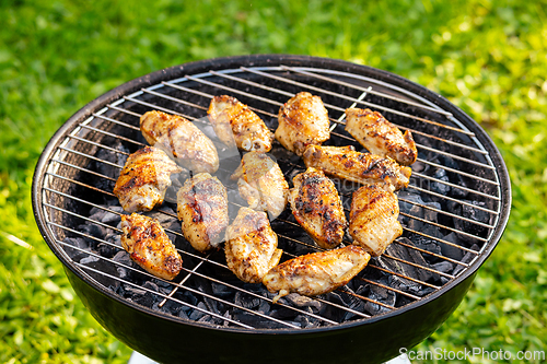 Image of chicken wings grilling on charcoal grill