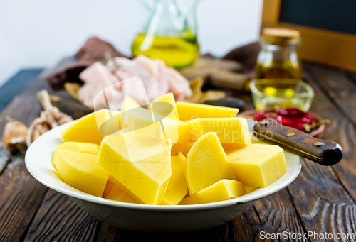 Image of raw potato and chicken on wooden table