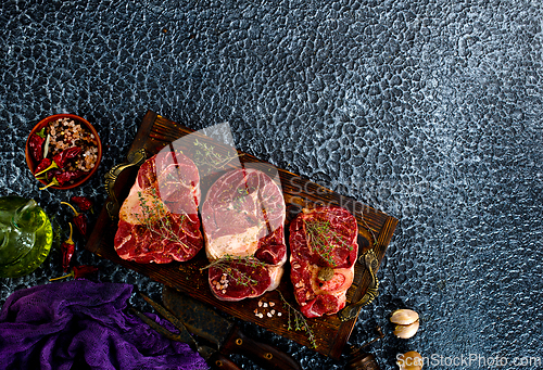 Image of A few steak pieces on the wooden board on a table