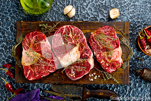 Image of A few steak pieces on the wooden board on a table