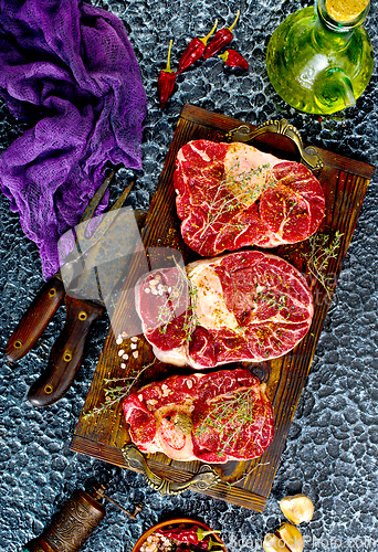 Image of A few steak pieces on the wooden board on a table