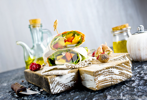 Image of Shawarma sandwich with vegetable and cheese. Traditional Middle Eastern snack. On wooden background