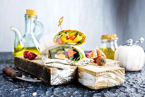 Image of Shawarma sandwich with vegetable and cheese. Traditional Middle Eastern snack. On wooden background