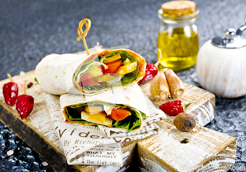 Image of Shawarma sandwich with vegetable and cheese. Traditional Middle Eastern snack. On wooden background