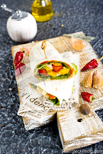 Image of Shawarma sandwich with vegetable and cheese. Traditional Middle Eastern snack. On wooden background