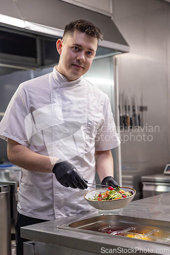 Image of Young chef preparing a fresh salad