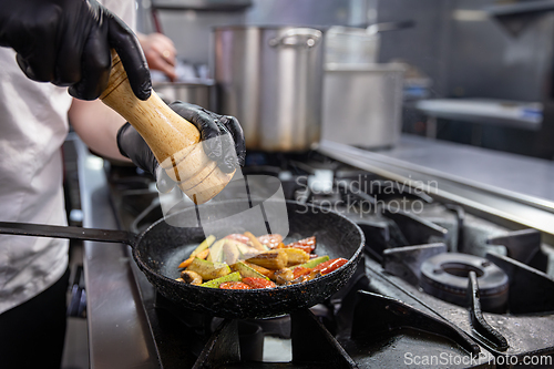 Image of Chef adding spices to grilled vegetables