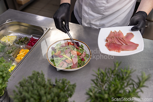 Image of Professional chef adding tuna slices