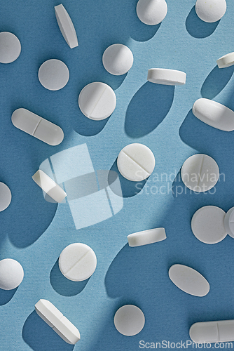 Image of white pills on sunny blue background