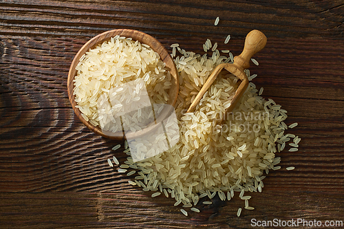 Image of raw rice in wooden bowl and spoon