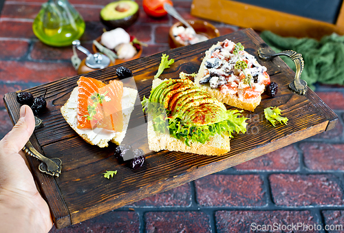 Image of Open sandwiches with salted salmon, guacamole avocado and microgreens.
