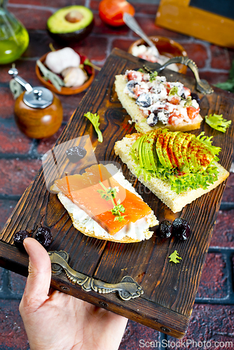 Image of Open sandwiches with salted salmon, guacamole avocado and microgreens.