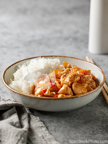 Image of bowl of boiled rice with chicken sweet and sour sauce