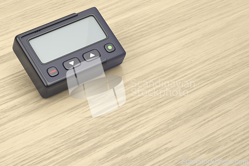 Image of Retro pager on wooden desk