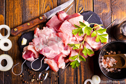 Image of Raw meat shish kebab skewers. Wooden background.