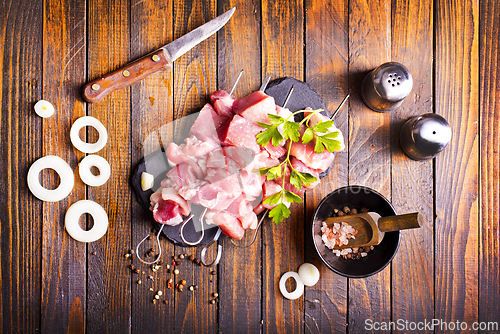 Image of Raw meat shish kebab skewers. Wooden background.