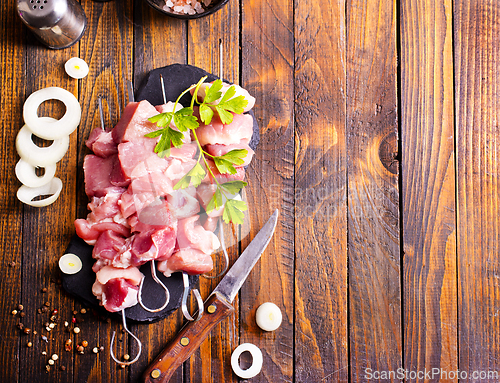 Image of Raw meat shish kebab skewers. Wooden background.