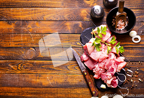 Image of Raw meat shish kebab skewers. Wooden background.