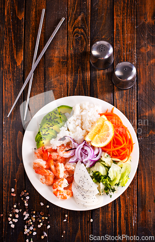Image of Poke bowl and ingredients on wooden table,