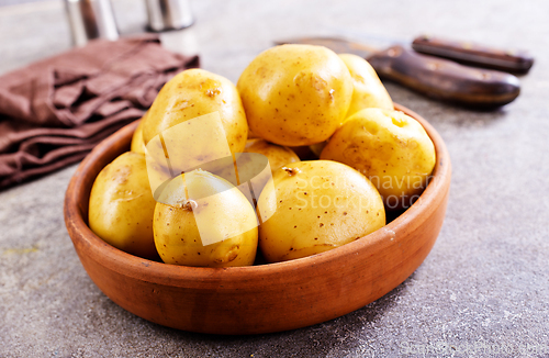 Image of bowl with raw potatoes on a table