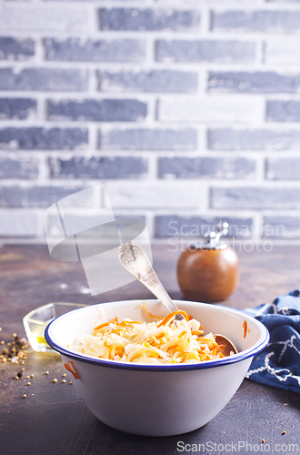 Image of Bowl of tasty sauerkraut on dark table. Sour cabbage top view