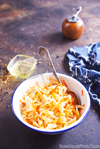 Image of Bowl of tasty sauerkraut on dark table. Sour cabbage top view