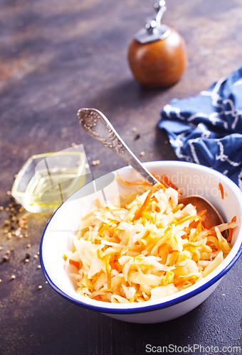 Image of Bowl of tasty sauerkraut on dark table. Sour cabbage top view