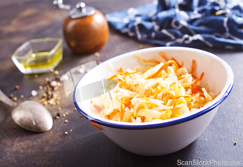Image of Bowl of tasty sauerkraut on dark table. Sour cabbage top view