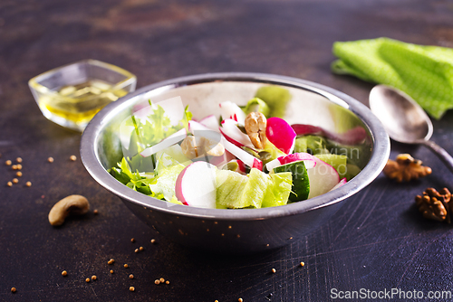 Image of A salad of fresh organic radish, cucumber with dill and green onions dressed with oil