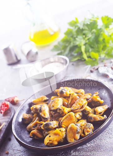 Image of spicy stir fried mussel with slice onion and spice on plate