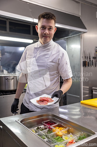 Image of Professional chef adding tuna slices