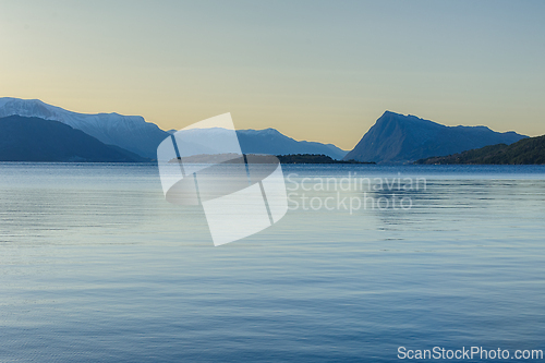 Image of Translucent waters reflecting mountains at twilight in a serene 