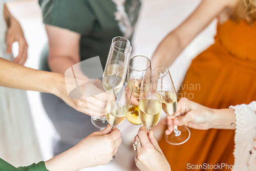 Image of Birthday surprise party. Group of cheerful female friends celebrating personal success stories. Smiling girls toasting with glasses of champagne