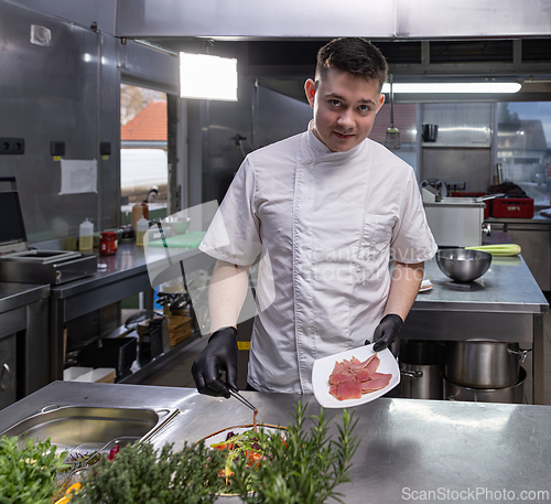 Image of Young chef adding smoked salmon