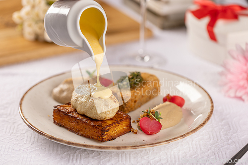 Image of Chef pouring sauce on chicken meatball