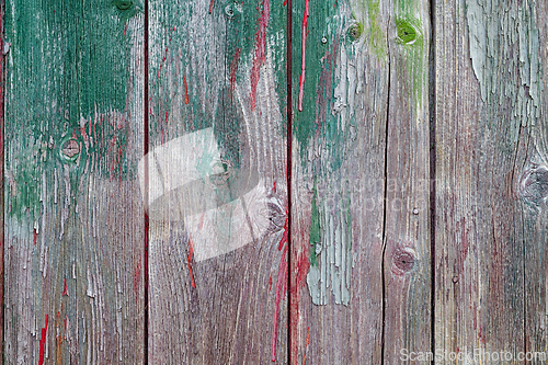 Image of Weathered wooden planks with green and red paint in an outdoor s