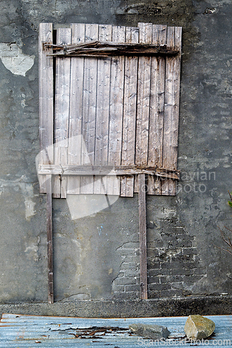 Image of Weathered wooden boards cover an old wall in an abandoned area d