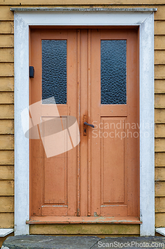 Image of Vibrant orange double door with textured glass panes on a charmi