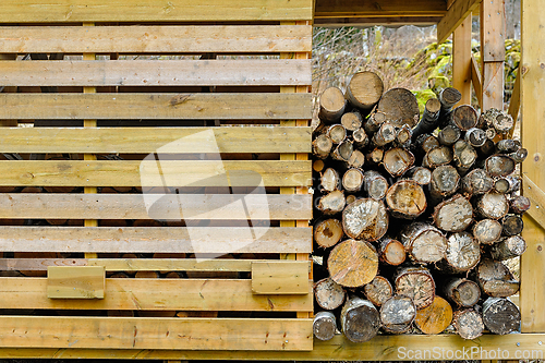 Image of Stack of firewood neatly organized in a wooden storage structure