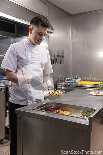 Image of Young chef preparing fresh salad