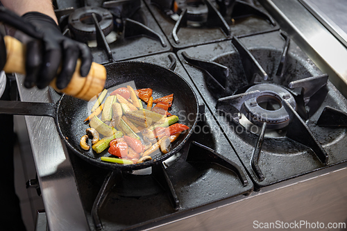 Image of Chef adding salt to grilled vegetables