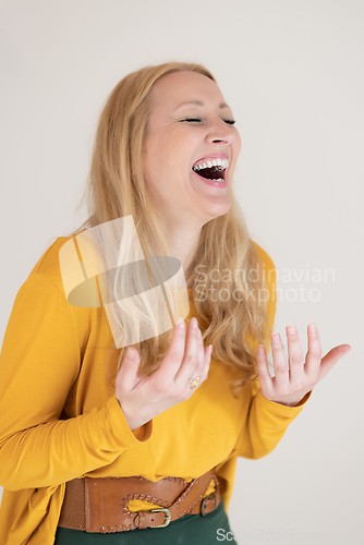 Image of Portrait of confident beautiful woman laughing, with long blende hair, wearing casual clothes, standing in welcoming pose with open hands, meditating