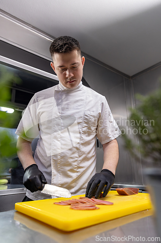 Image of Professional chef showing a perfect slice of smoked fish