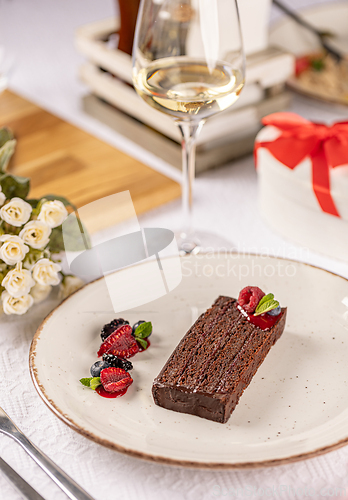 Image of Chocolate cake slice decorated with fresh raspberries